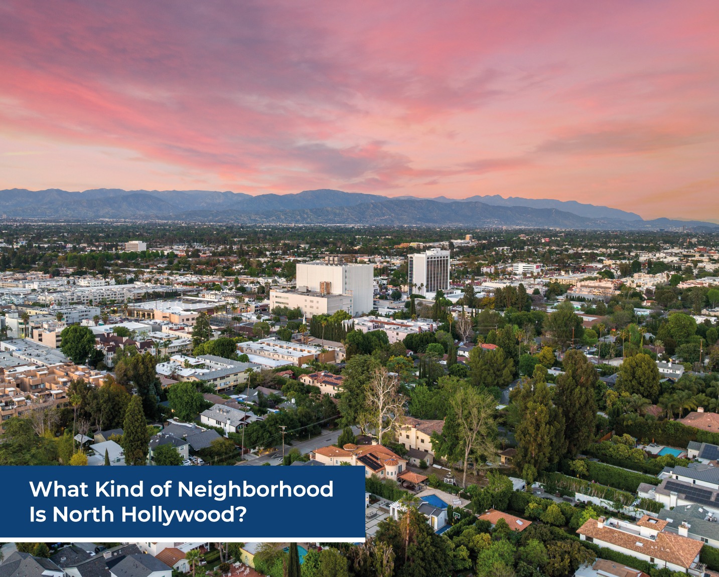 Aerial view of North Hollywood neighborhood with houses, buildings, and mountains at sunset
